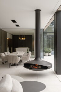 Bromic Platinum Smart Heat Electric Black installed in luxury outdoor living space with fireplace.